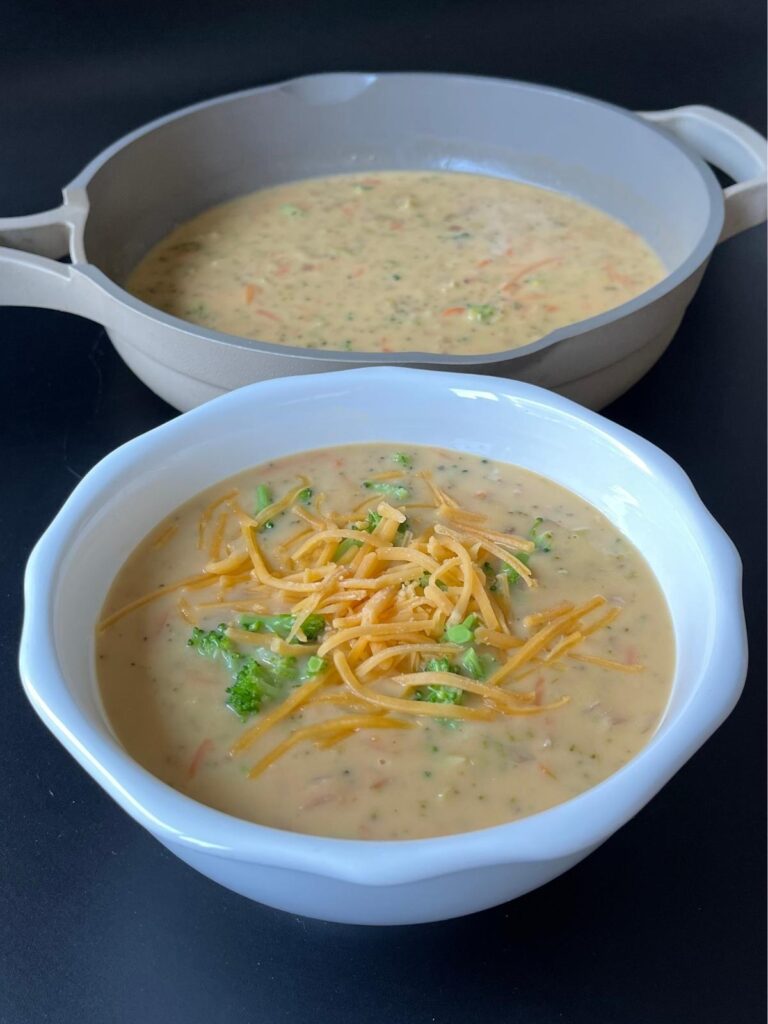 bowl of keto broccoli cheddar soup with pan behind it