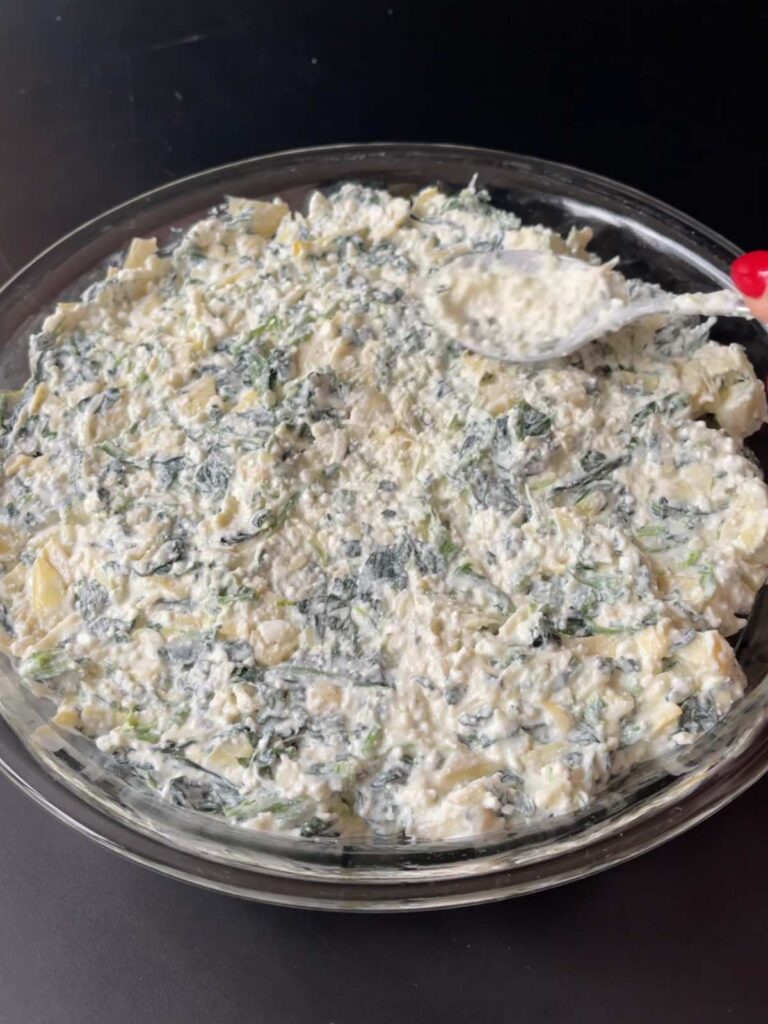 spreading the high protein spinach artichoke dip into the baking oan